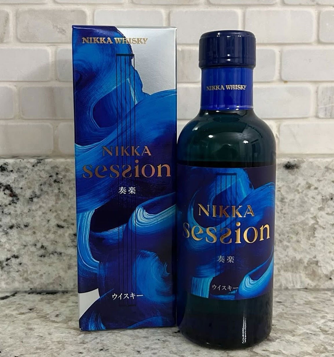 Nikka Session whisky bottle and packaging on a countertop with a tiled wall background price philippines